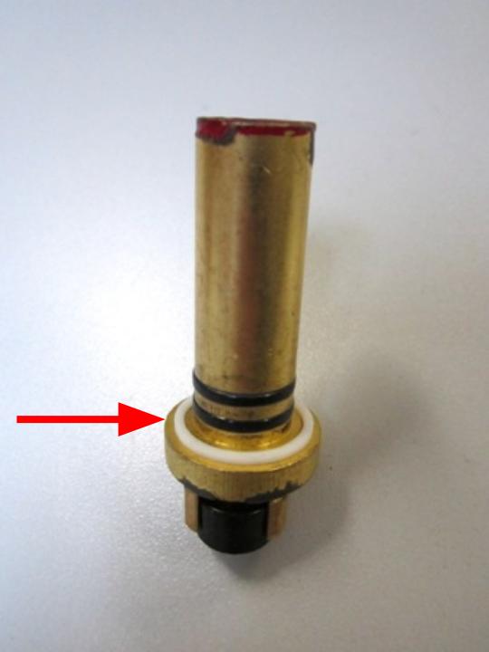  Install the rubber seal and plastic seat on top of the spring.