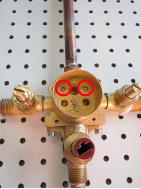 Locate the locating pins on the bottom of the cartridge and locate the corresponding holes in the faucet body.