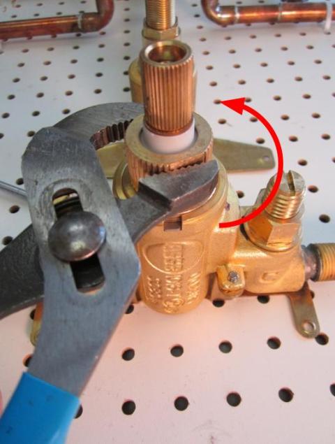 Using a pair of adjustable pliers, remove the locking nut by turning counter-clockwise.