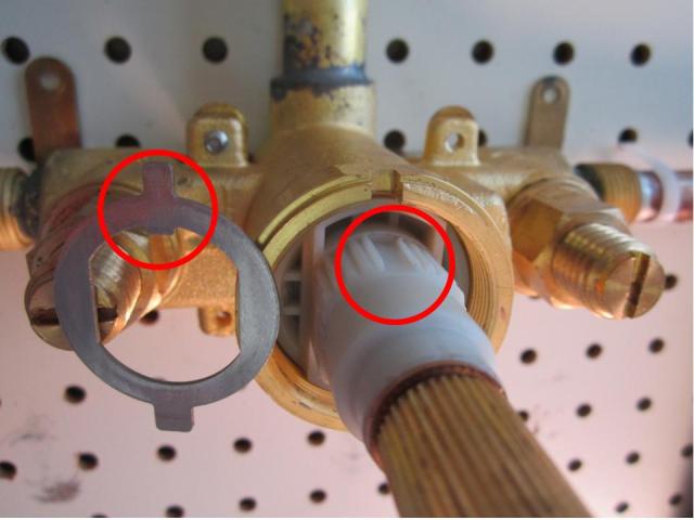 Install the fixed washer on the new cartridge. The opening is round on the inside bottom, flat on the inside left and right, and has a small notch on the inside top.  It can only fit onto the cartridge one way.  Line the small notch up with the matching groove that runs along the top of the cartridge.