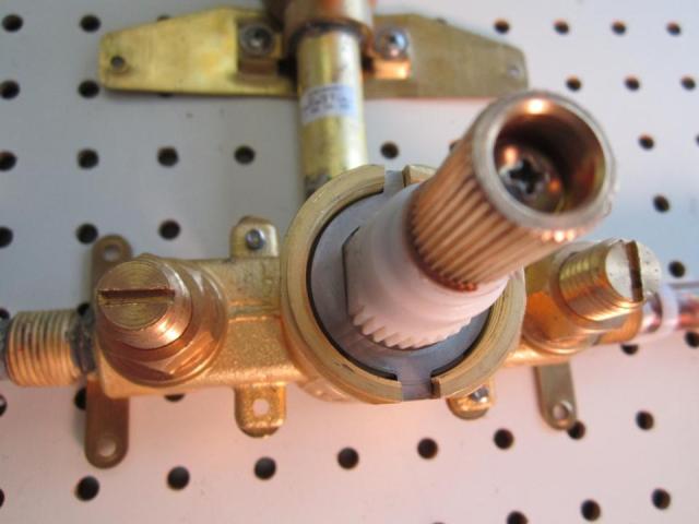 Install the fixed washer on the new cartridge. The opening is round on the inside bottom, flat on the inside left and right, and has a small notch on the inside top.  It can only fit onto the cartridge one way.  Line the small notch up with the matching groove that runs along the top of the cartridge.