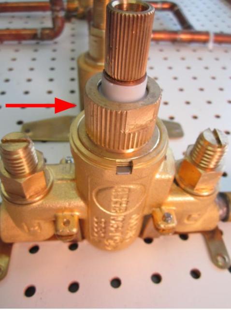 Using a pair of adjustable pliers, remove the locking nut by turning counter-clockwise.